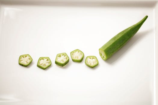 Top view of fresh okra slices neatly arranged on a white plate, highlighting their texture.